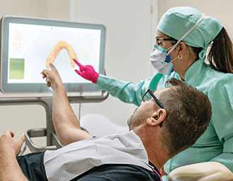 dentist and patient look at an image provided by a dental lab